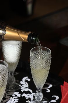 Pouring a glass of sparkling champagne for New Year