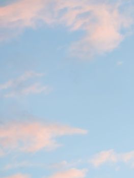 Background of blue sky with pale pink clouds at sunset