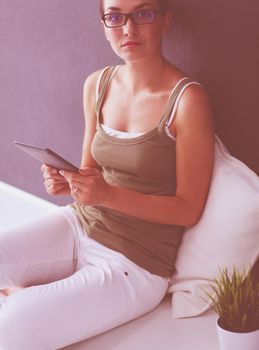 Woman sitting on the floor using a digital tablet.