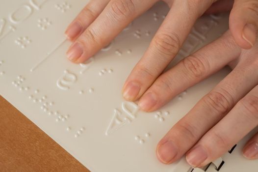 A woman learns the Braille alphabet using a decoder