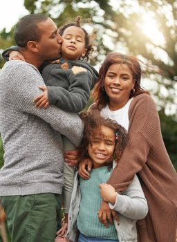 Our family was built from love. a young family standing outside together and posing in their garden