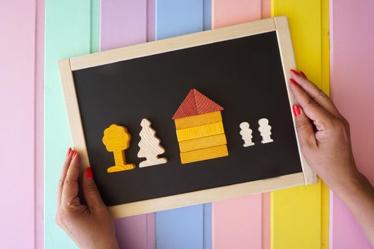 Women's hands lay out figures made of cubes on the board . High quality photo