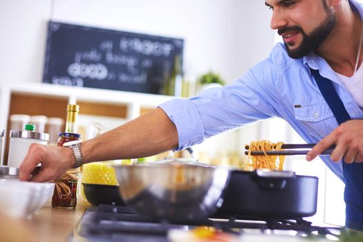 Man preparing delicious and healthy food in the home kitchen.