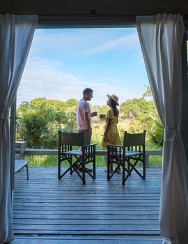 couple on safari in South Africa, Asian women and European men at a tented camp lodge during the safari. Couple of men and a woman are on vacation in South Africa