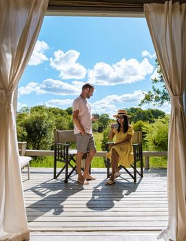 couple on safari in South Africa, Asian women and European men at a tented camp lodge during the safari. Couple of men and a woman are on vacation in South Africa