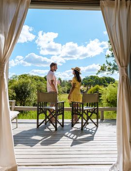 couple on safari in South Africa, Asian women and European men at a tented camp lodge during the safari. Couple of men and a woman are on vacation in South Africa