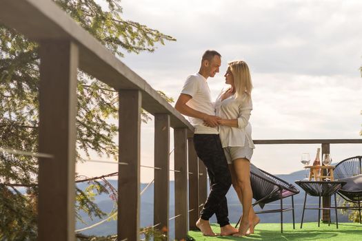 Happy couple at outdoor terrace in the mountains. Romantic time together.