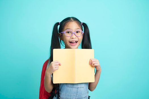 Close-up kid students girl smiling holding book, going to school. school concept.