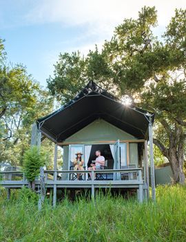 couple on safari in South Africa, Asian women and European men at a tented camp lodge during the safari. Couple of men and a woman are on vacation in South Africa