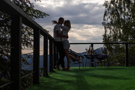 Happy couple at outdoor terrace in the mountains. Romantic time together.