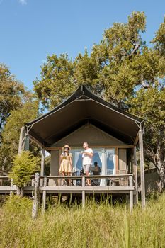 couple on safari in South Africa, Asian women and European men at a tented camp lodge during the safari. Couple of men and a woman are on vacation in South Africa