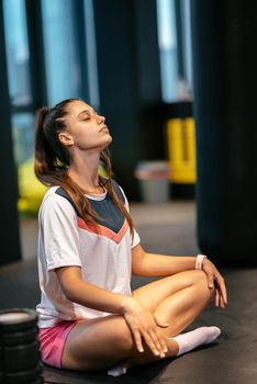 Young sporty woman practicing yoga, working out, wearing sportswear, indoor full length, yoga studio
