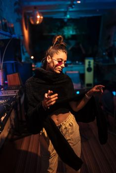 Beautiful female DJ dancing to techno