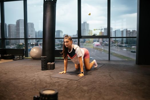 Young woman doing exercises in the gym during morning
