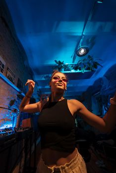 Beautiful female DJ dancing to techno