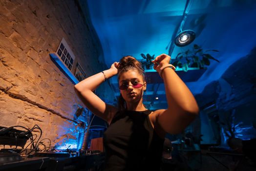 Beautiful female DJ dancing to techno