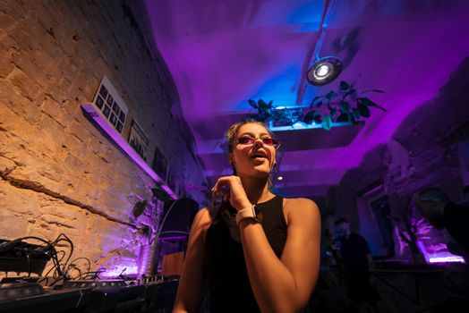 Beautiful female DJ dancing to techno