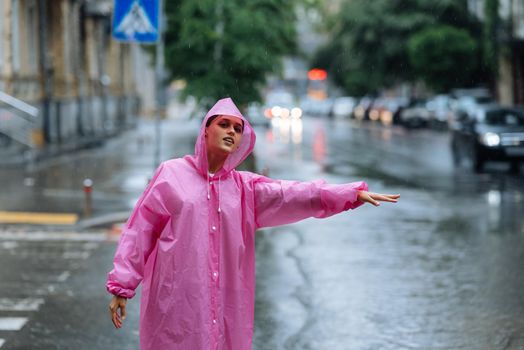 Woman catching taxi. Young girl trying to stop a cab. Woman calling a taxi on a rainy day.