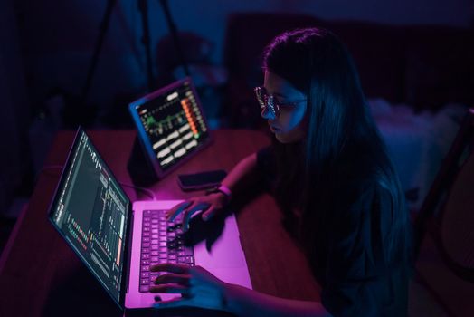 Attractive young woman working in home at night. Girl using laptop.