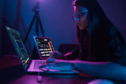 Attractive young woman working in home at night. Girl using laptop.