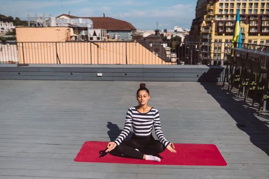 Beautiful young woman doing yoga exercise, meditation in lotus pose