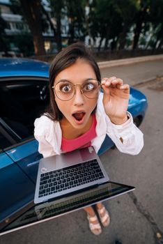 Shocked young brunette hold in hands laptop