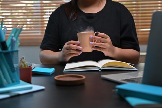 Young woman hands holding hot cup of coffee or tea.
