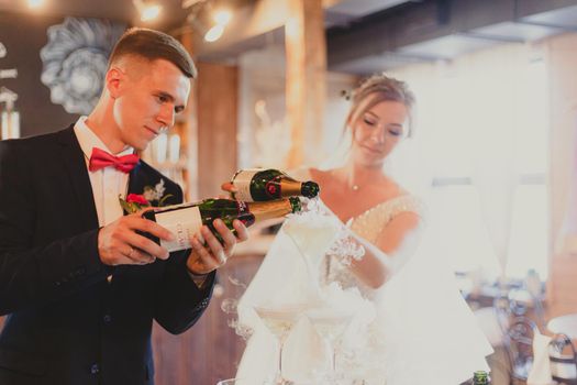 The bride and groom fill the champagne fountain. Wedding article. A happy couple. Love. Photos for printed products. Romance. Wedding catalog