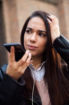 vertical photo of a worried woman recording a voice message with her telephone, concept of technology and communication