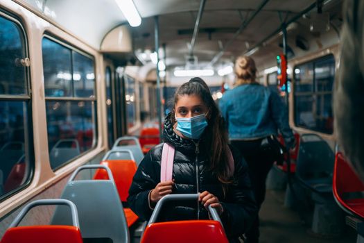 Young woman with mask traveling in the public transport by bus. Unique protective mask of the respiratory tract from coronavirus.