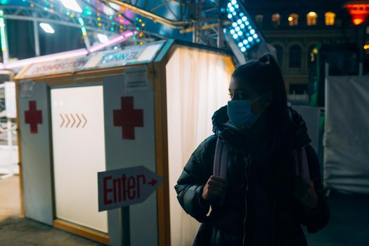 Young beautiful woman in a medic mask is staying at a disinfection tunnel