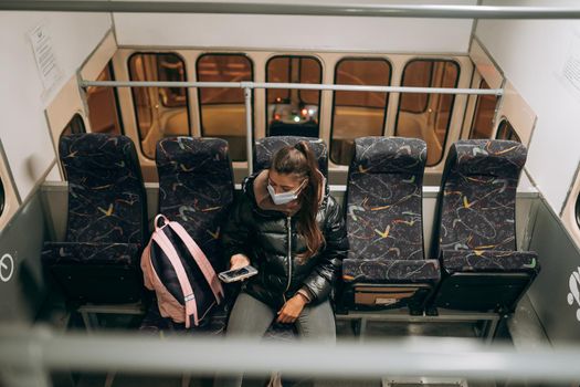 Young woman with mask traveling in the public transport by bus. Unique protective mask of the respiratory tract from coronavirus.