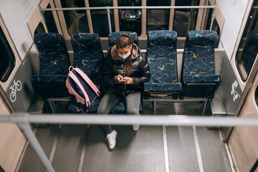 Young woman with mask traveling in the public transport by bus. Unique protective mask of the respiratory tract from coronavirus.