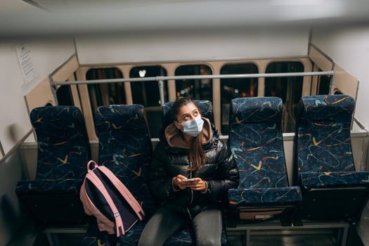 Young woman with mask traveling in the public transport by bus. Unique protective mask of the respiratory tract from coronavirus.