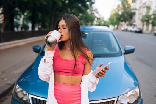 Woman drive car stop coffee break pause , use smartphone read social network news in city center