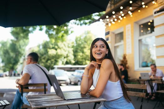 Young woman sitting in a street cafe