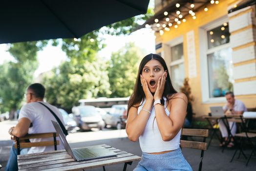 Young woman sitting in a street cafe