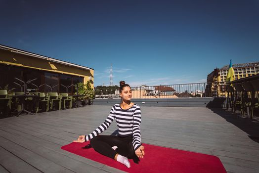 Beautiful young woman doing yoga exercise, meditation in lotus pose