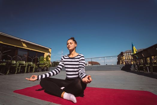 Beautiful young woman doing yoga exercise, meditation in lotus pose
