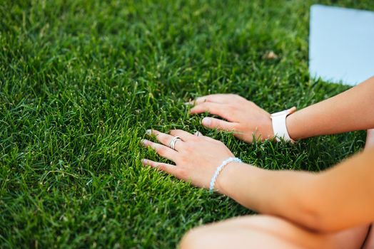 Young fit attractive woman lying on green lawn park. Perks of freelance concept. Background, copy space