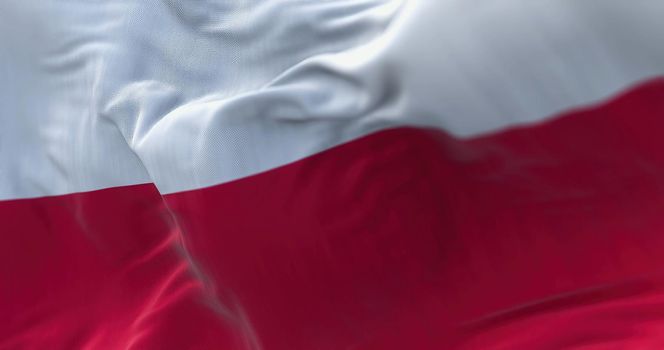 Close-up view of the Poland national flag waving in the wind. Poland is a country in Central Europe. Fabric textured background. Selective focus