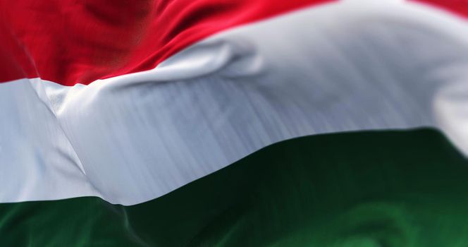 Close-up view of the Hungary national flag waving in the wind. Hungary is a landlocked country in Central Europe. Fabric textured background. Selective focus