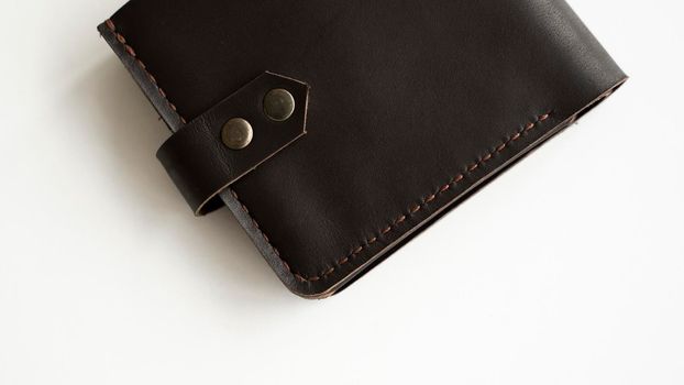 Man's handmade dark brown genuine leather wallets on a white background. Leather goods and accessory