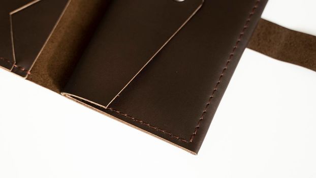 Man's open handmade dark brown genuine leather wallets on a white background. Leather goods and accessory