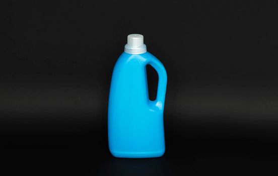 Blue plastic bottle with a grey cap isolated on black background for liquid detergent laundry or cleaning agent. Packaging template mockup