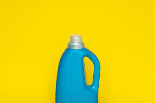 Blue plastic bottle with a grey cap isolated on yellow background for liquid detergent laundry or cleaning agent. Packaging template mockup