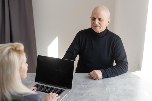 Close up of smiling young Caucasian female therapist or GP have consultation with old male patient in clinic or hospital. Happy woman doctor talk consult elderly man client. Healthcare concept.