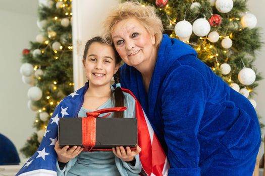 Christmas in America. grandmother and granddaughter celebrate Christmas or New Year on american flag background. Happy family in USA.