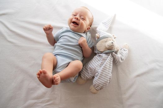 The baby is lying in his crib and looking at the camera . A happy child. Children's article. Copy Space