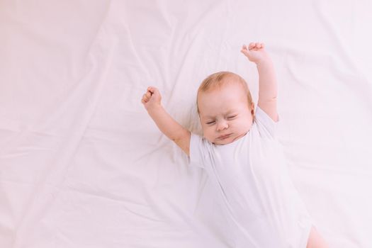 The baby stretches after sleeping Lifestyle . A happy child. Children's article. Copy Space